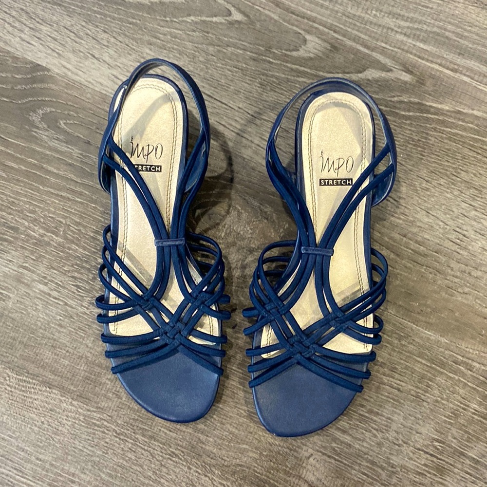 Dark blue, slightly heeled shoes with cris crossing elastic on top.